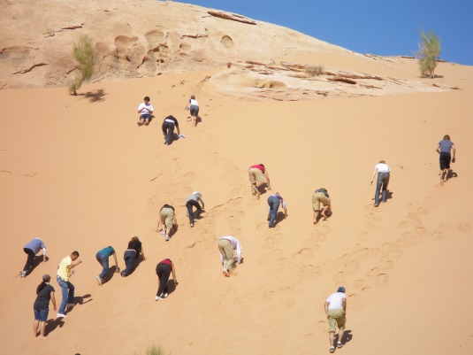 East West Students Climbing a sand dune- not exactly a day at the beach